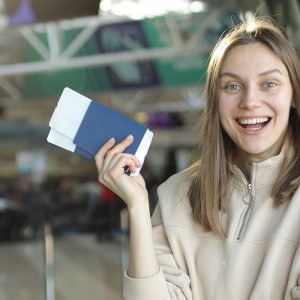 portrait-of-happy-young-woman-holding-passport-and-2EMUGAY.jpg